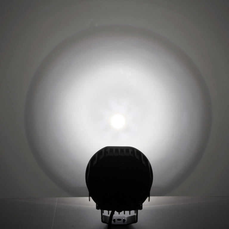 Rear view of the Auxbeam 360 Ultra 6-inch LED light with its round spot beam glowing on a wall