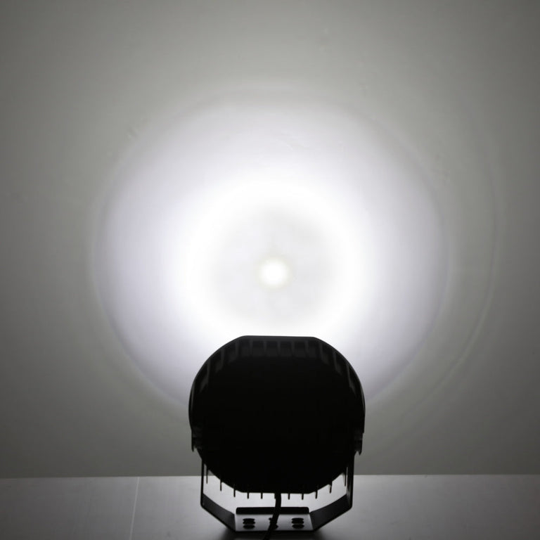 Rear view of the Auxbeam 360 Ultra 8.5-inch LED light with its round spot beam glowing on a wall
