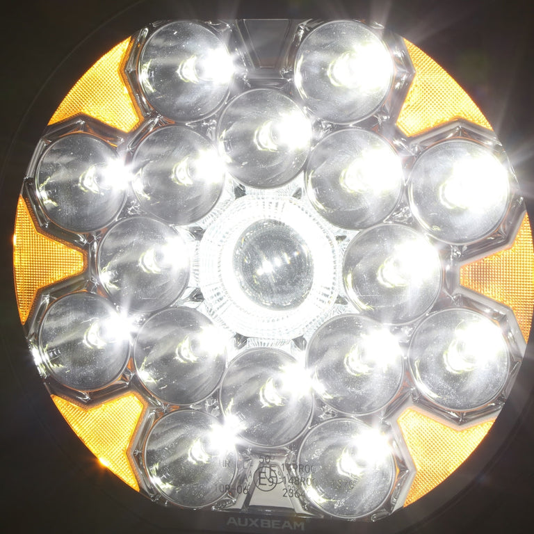 Front view of the Auxbeam 360 Ultra LED light lit, showing 16 spot LEDs, center projector and amber DRL ring